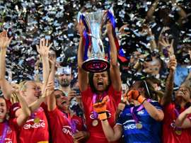 Olympique Lyonnais captain Wendie Renard holds the trophy to celebrate with teammates after winning the UEFA Womens Champions League Final football match VFL Wolfsburg vs Lyon in Reggio Emilia, Italy on May 26, 2016