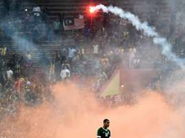 Yasyn Alnakhli of Saudi Arabia walks off the pitch after flares were thrown by football fans during the 2018 World Cup qualifying match between Malaysia and Saudi Arabia in Shah Alam on September 8, 2015