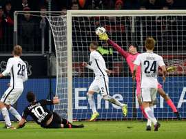 Le milieu Hakan Calhanoglu, au sol, inscrit le 3e but de Leverkusen contre le Hertha BSC Berlin. AFP