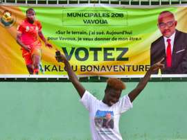 Une Ivoirienne danse devant l'affiche électorale de Bonaventure Kalou. AFP