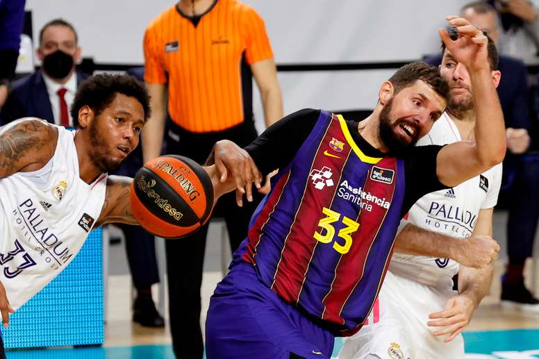 El ala pívot del Real Madrid Trey Thompkins (i) lucha con Nikola Mirotic, del Barça, durante un partido. EFE/Chema Moya/Archivo