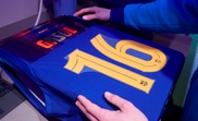 Un trabajador de una tienda del FC Barcelona estampa la nueva camiseta del Pau Gasol.EFE/ Alejandro García/Archivo